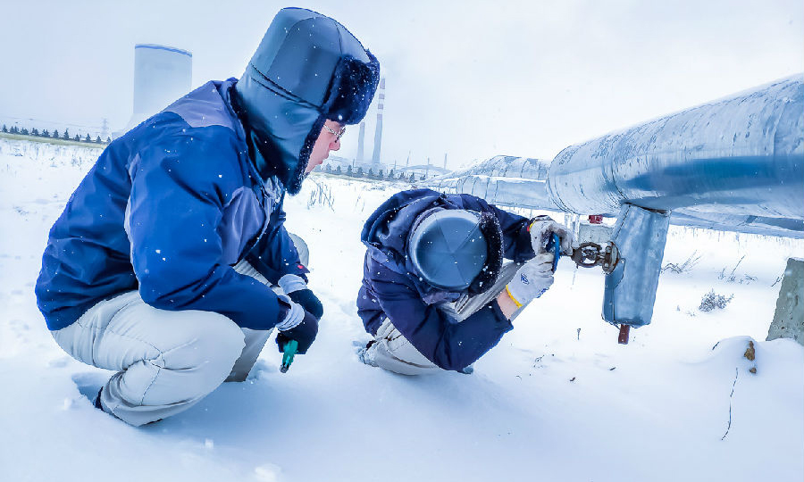 近日，北方地区普降大雪，气温骤降。国家能源集团相关单位积极应对大雪来袭，积极保供。国华胜利电厂维护部汽机班员工检查厂区采暖管道放水阀门。（段超 摄）