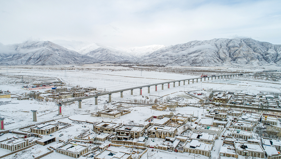 图为中铁十一局铺架队顶风冒雪架设拉林铁路首座声屏障桥梁。（丁庆滨 摄） 