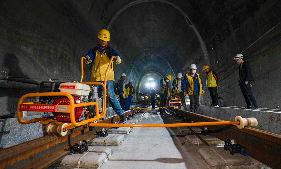 拉林铁路是西藏首条电气化铁路，建成通车后将结束藏东南地区没有铁路的历史，改善西藏铁路网的布局和规划，为西藏东部地区的经济发展注入新的活力。目前，项目已完成正线铺轨126.3公里，其中有砟109.5公里、无砟15.7公里，预计今年年底完成全线铺轨任务。图为施工人员正在对已铺设好的轨道安装扣件。