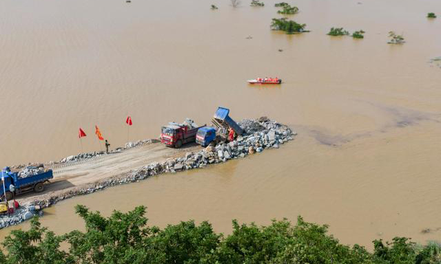 7月8日晚，江西省鄱阳县鄱阳镇问桂道圩堤发生漫决。险情发生后，中国安能第二工程局迅速调集抢险人员、工程装备前往决口现场，打响防汛抢险阻击战。截至7月12日下午，决口封堵进度已经过半。 图为7月12日，无人机拍摄的问桂道圩堤施工现场。