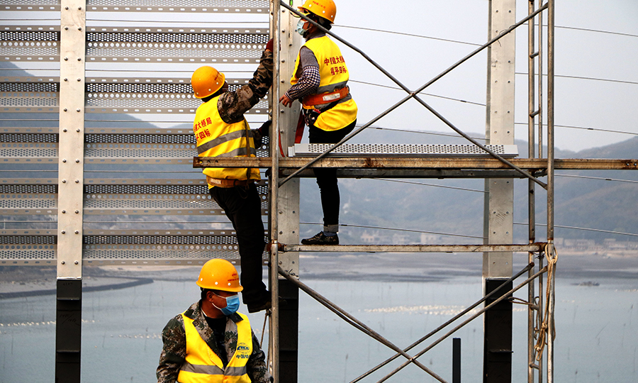 图为建设者安装风屏障。