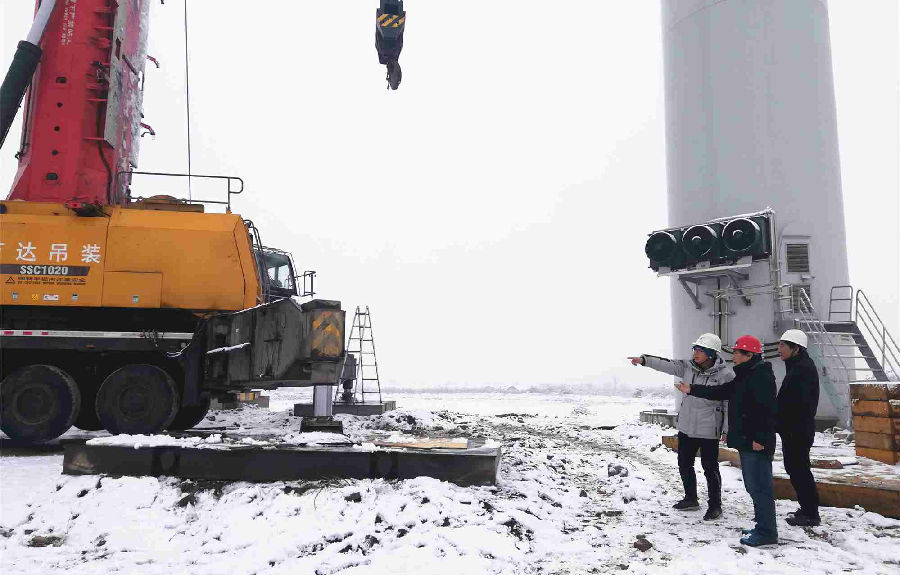 1月5日至6日，全国多地迎来降雪。航天科技干部职工顶风冒雪奋战在科研生产一线，成为2020年开年的一道亮丽风景。图为航天科技一院万源国际工作人员正在勘察执行风力发电机组吊装任务的吊车组装情况。（盖明君 摄）