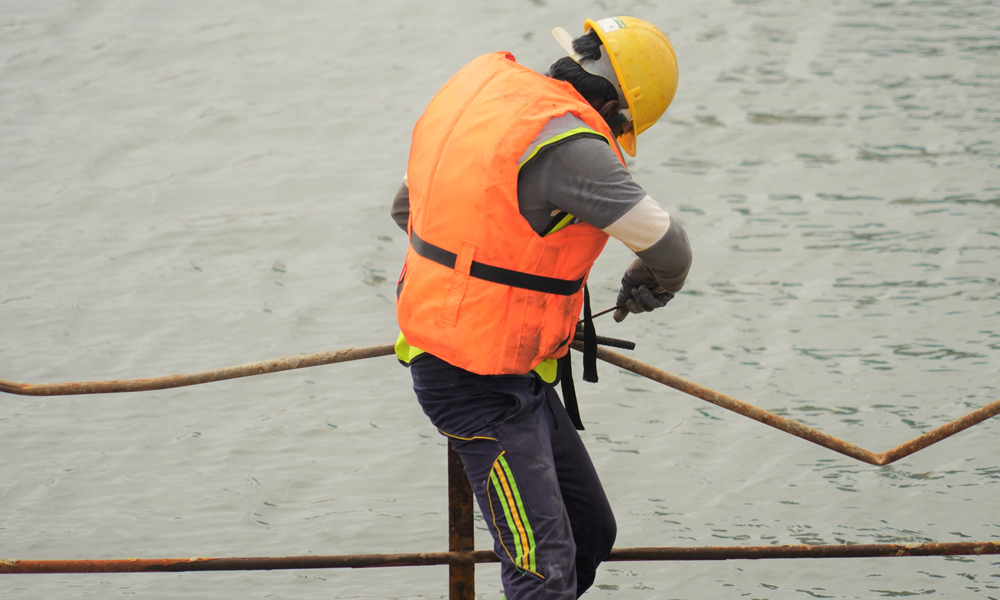 图为7月22日，一名当地工人在斯里兰卡科伦坡港口城景观水道区域准备安装安全护栏。（新华社记者 唐璐 摄）