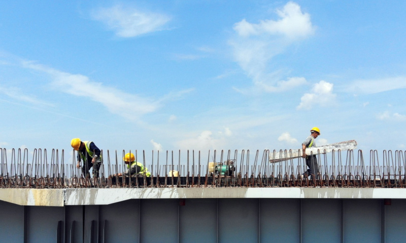 长春连日来持续高温。为确保京哈高速长春至拉林河段改扩建工程按期完工，中国交通建设股份有限公司的千余名筑路工人冒着高温，奋战在热浪滚滚的一线工地，加紧进行路基、路面、桥涵和环保绿化等工程施工。图为7月9日，工人在京哈高速长春至拉林河段改扩建工程现场施工。（新华社记者 林宏 摄）