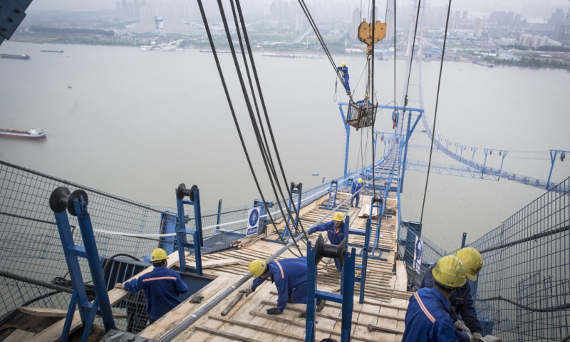 6月8日，在离地200余米的高空，工人们加紧施工作业。（新华社记者 肖艺九 摄）