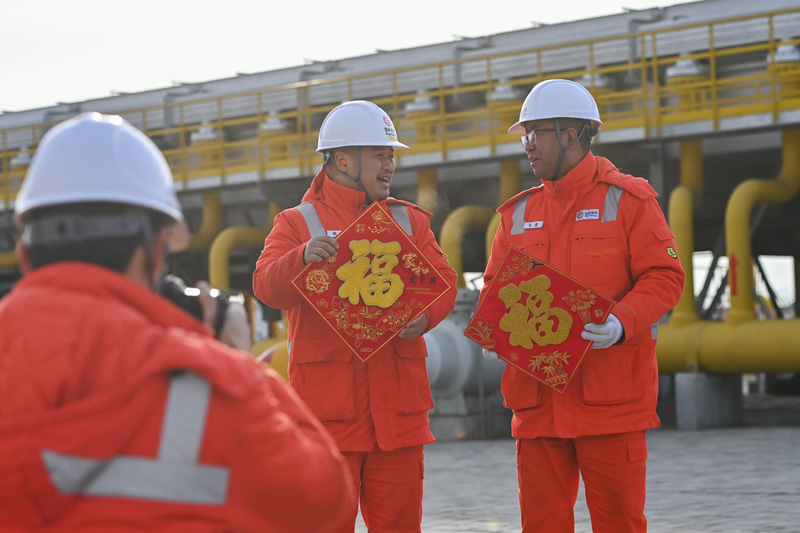 图为2月4日，在霍尔果斯压气首站，运维人员录制视频为家人送上新春祝福。（新华社记者 丁磊 摄）