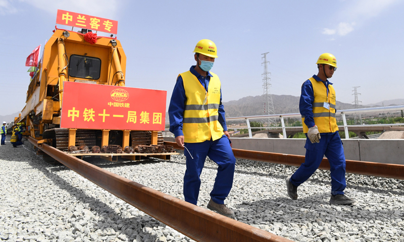 图为5月30日，中铁十一局建设者在中兰客专甘肃段铺轨施工现场作业。（新华社记者 陈斌 摄）