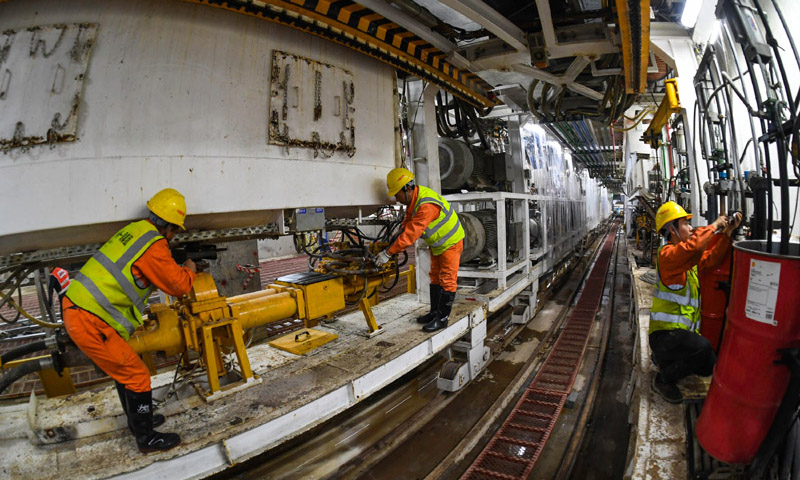 图为施工人员在广州地铁10号线东湖站盾构井检查调试盾构机设备管线。（新华社记者 刘大伟 摄）