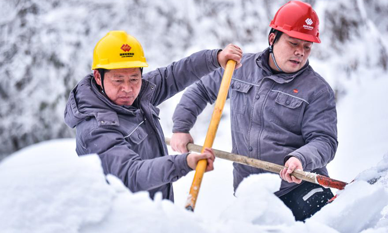 图为42坝一级水电站两名员工沿着引水渠道前行，不时将渠道周边积雪推进引水渠道，为二、三、四级水电站争取更多的水源。大雪期间，这是员工们的“必修课”。