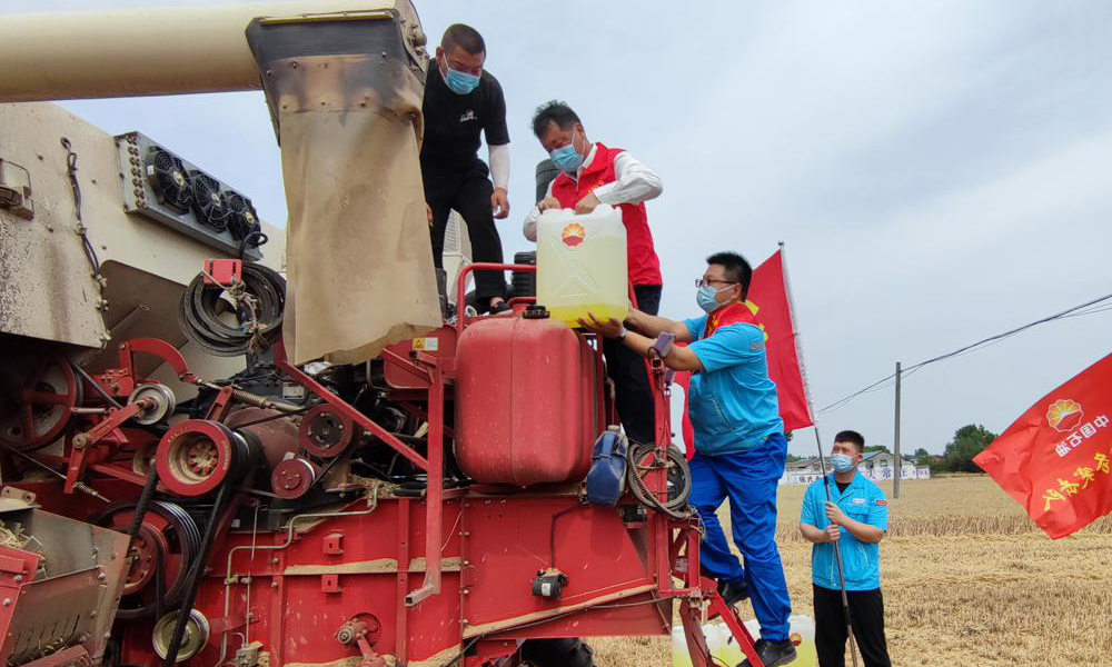 近期，我国多地进入“三夏”农忙时期。为保证各地夏收用油充足供应，中国石油所属销售企业迅速行动，为夏粮颗粒归仓加油助力。中国石油河南销售公司推出农机用油、润滑油及化肥惠农政策，组建20支送油小分队送油到田间地头，为农机手和农户及时提供农机维修、政策咨询、气象查询等信息服务。图为中国石油河南销售南阳分公司党员保供突击队送油到田间地头。赵崇阳 摄 