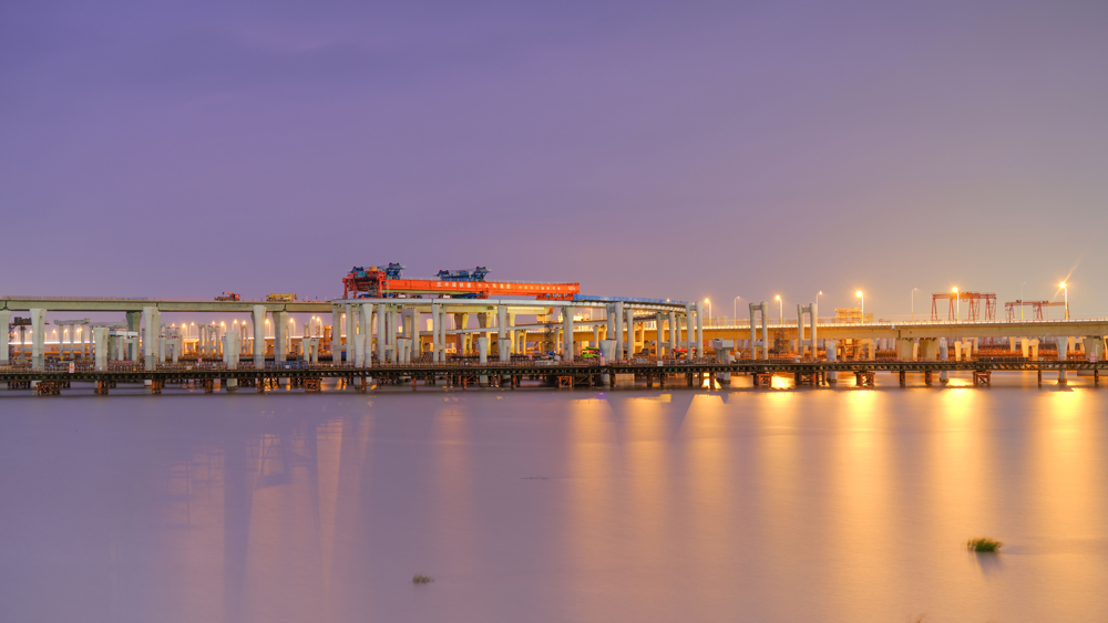 11月3日凌晨，由中国铁建所属中铁十六局负责架梁施工的亚洲最大海上互通主线桥——杭甬高速复线宁波一期工程滨海互通主线桥成功上跨甬舟高速金塘大桥。图为“越海号”架桥机架梁施工现场。