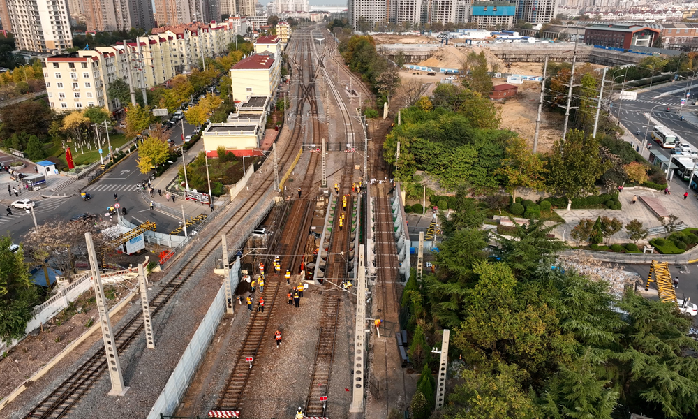 胶济客专海岸路桥位于青岛站和四方站间，是连接青岛站与青岛北站的唯一动车通道，是山东省境内服役年限最长的铁路钢梁桥。该桥由上下行共4片钢梁组成，梁体锈蚀严重、承载力不足、部分支承垫石开裂，造成一定的安全隐患，为确保铁路行车和桥下交通安全，需进行更换。图为旧梁拆除前。