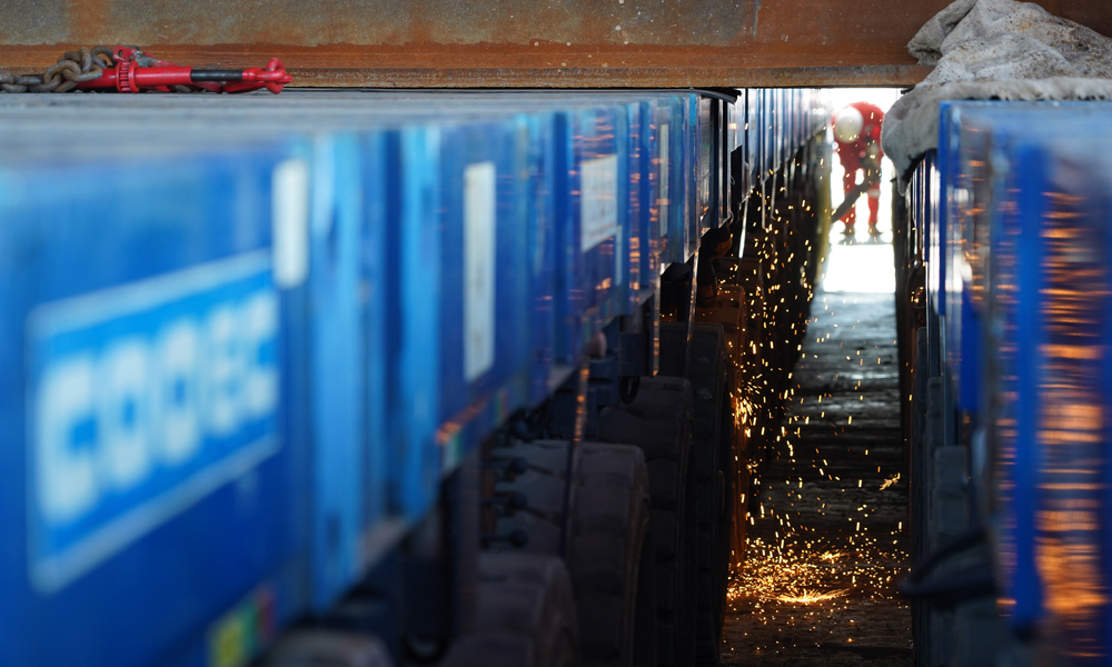 9点，驳船上焊花四起，刚刚装上船的组块被焊接到驳船上固定。10点，阳光已经变得有些炽热。SPMT小车的轮胎反向转动，倒车撤出组块，装船作业结束。