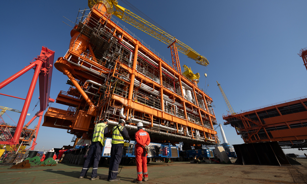 工作人员从驳船回到码头，朝车间走去，他们顾不上休息，不久后，正在岸边加紧建造的生活楼也要从他们手中送到海上去，送到油气生产平台上，为国内油气增储上产注入澎湃动能。