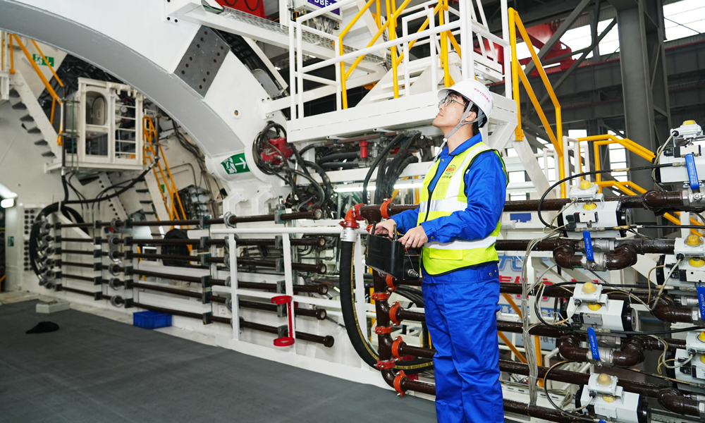 厦金大桥（厦门段）主线长约17.34公里，由海上桥梁和陆地隧道两部分组成，其中位于厦门市思明区环岛东路的主线隧道全长3291米，盾构段为左右双线隧道，采用一台盾构机掘进施工。其中，左线长度为1334米，右线长度为1038米，为单洞单层盾构形式，双向六车道，设计时速80公里。图为技术人员在调试盾构机。