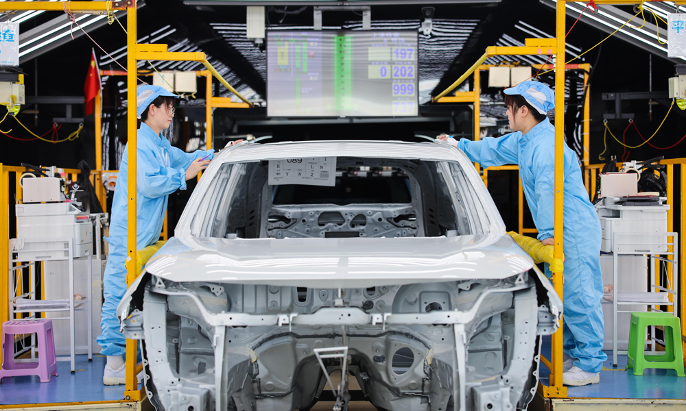 工作人员在位于天津市的一汽丰田涂装车间检查车身顶盖漆面。