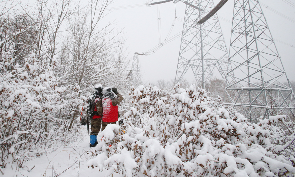近日，受蛇年首场寒潮影响，我国中东部地区气温持续走低，局地气温下降10摄氏度以上。国家电网有限公司坚决扛牢电力保供首要责任，加强对重要变电站、线路及供暖设施的巡检特护和运行监控，全力保障电网安全运行和电力可靠供应，用心守护人民群众温暖度冬。图为国家电网辽宁本溪供电公司工作人员对500千伏丰徐线“三跨”重要区段开展特巡特护。