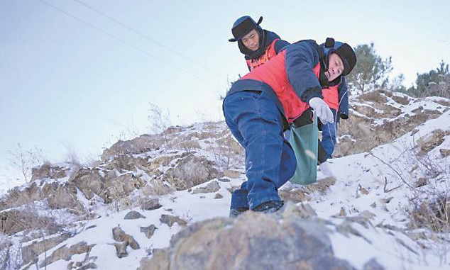 国家电网蒙东通辽奈曼旗供电公司工作人员巡检10千伏青龙山线后相互搀扶下山。