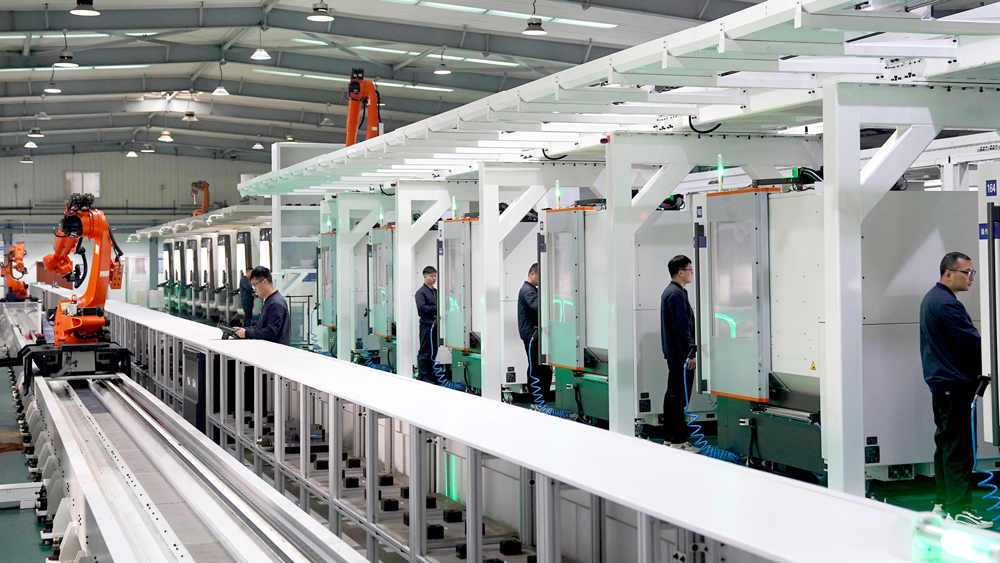 工作人员在设备前调试加工程序，力求尽早完成各项产品加工交付。赵书剑 摄