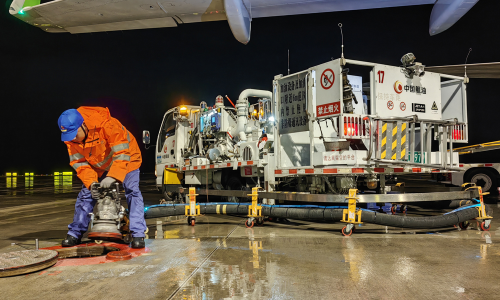 中国航油贵州分公司航空加油站飞机加油员进行雨中加油作业。