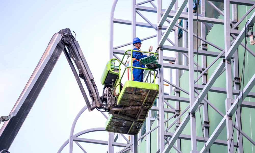 南方电网海南电网公司施工人员在220千伏碧海变电站开展建筑楼玻璃幕墙外立面施工。