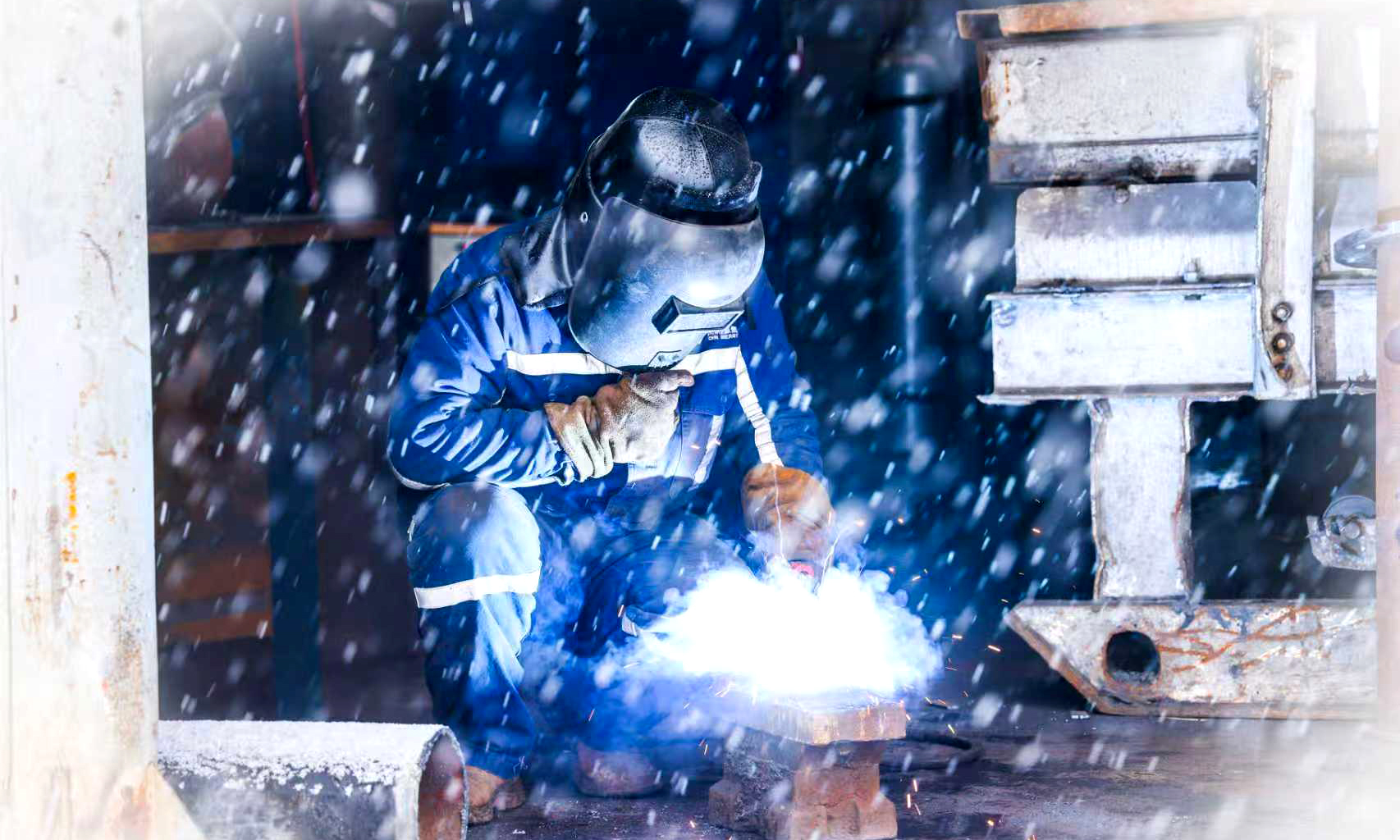 在榆林能源郭家湾矿机修厂，雪花与焊花交相辉映。焊工师傅为综掘队焊接除尘风机底座，以精湛技艺保障井下设备设施完好可靠，为矿井安全生产保驾护航。
