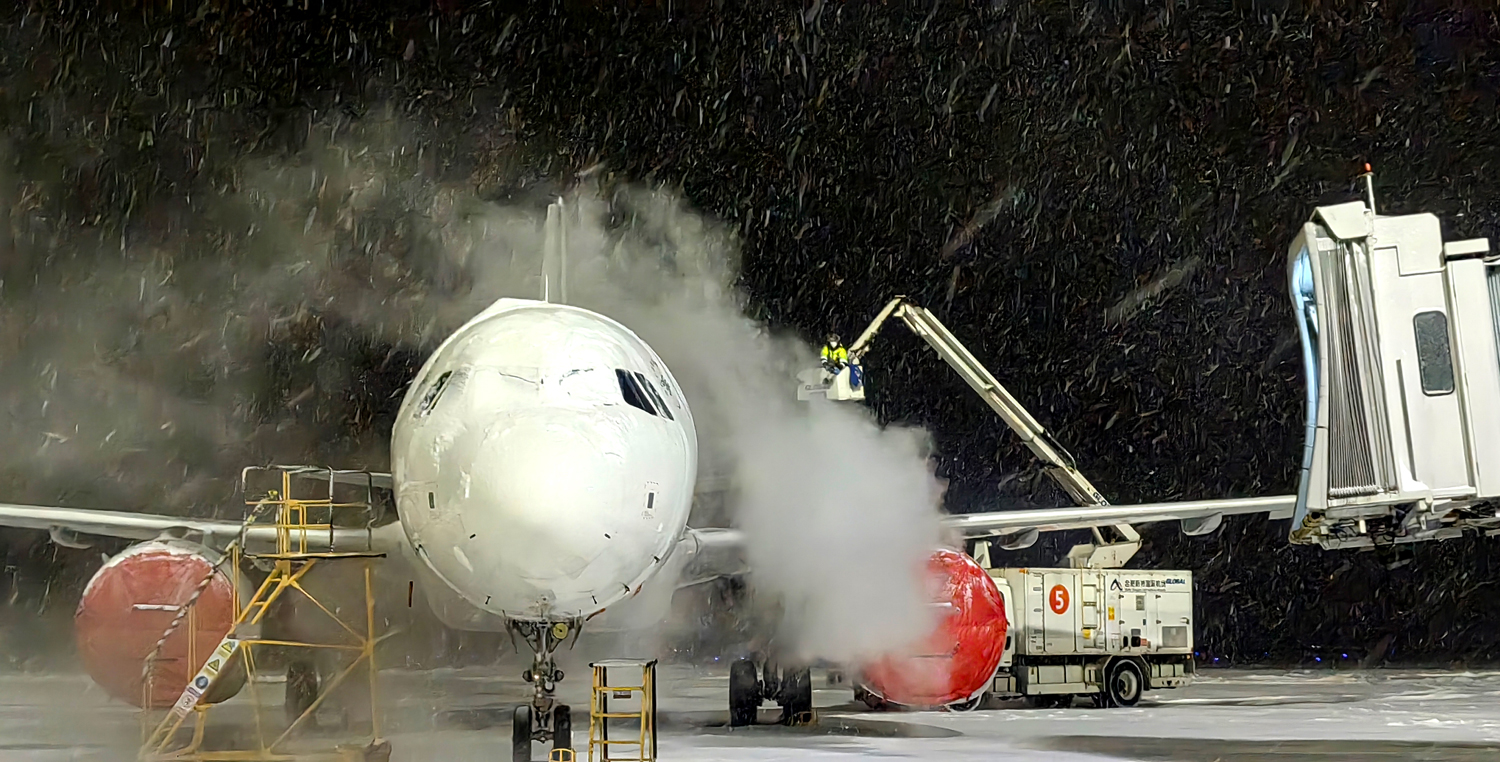 合肥新桥国际机场寒风凛冽，中国东航机务工作人员开展除冰作业。