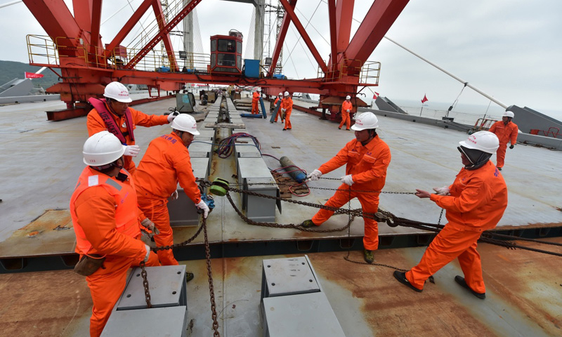 图为12月28日，工人在平潭海峡公铁两用大桥大小练岛水道桥钢桁梁合龙时的桥面进行作业。（新华社记者 林善传 摄）