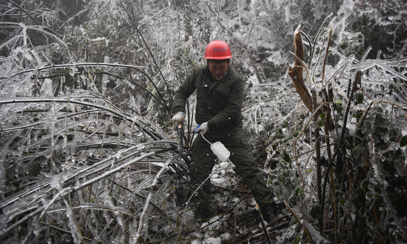 近日，湖南遭遇持续冻雨袭击。地处雪峰山山区的湖南省娄底市新化县海拔较高，部分区域冰冻严重，多处电路受损，当地居民用电受到影响。国网新化县供电公司派出电力工人，对新化县温塘镇郭家村10kv高压线进行紧急抢修。工人在山间破冰除雪，为当地村民恢复供电。图为2月20日，在新化县郭家村，电力工人刘桂湘清除电线上的覆冰。（新华社记者 薛宇舸 摄）