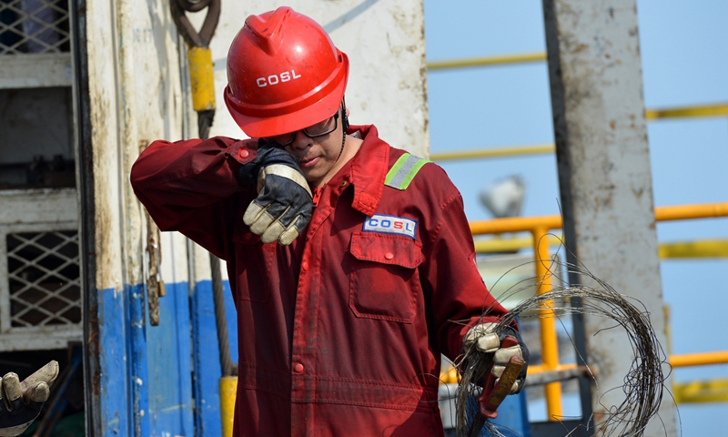 图为7月8日，中国海油“海洋石油932”钻井平台工作人员正在作业。