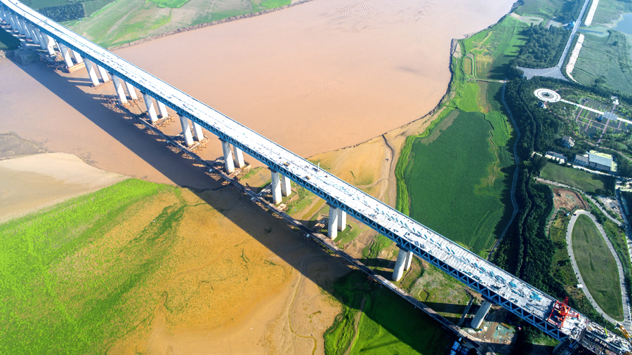 浩吉铁路一跨长江，两跨黄河，依次跨越汉江、长江、洞庭湖和赣江等水系。全线建设700多座大中桥，其中5公里以上特大桥有10座，洞庭湖特大桥、龙门黄河大桥等为全线重点控制性工程。图为中国铁建大桥局承建的三门峡黄河公铁两用大桥，该桥为连续钢桁梁桥，其中钢桁梁顶推创下长度、重量两项世界之最。