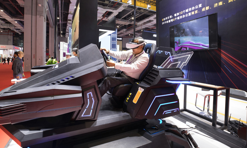 图为11月5日，一名参观者在第二届进博会科技生活展区体验虚拟现实赛车。（新华社记者 金立旺 摄）