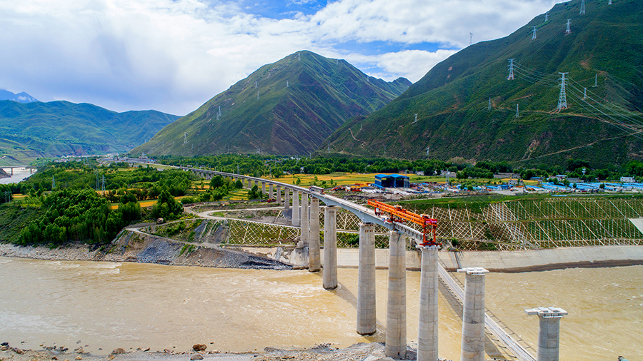 7月4日，由中国铁建所属中铁十一局三公司承建的拉林铁路加查1号雅鲁藏布江特大桥顺利完成桥梁架设任务，标志着拉林铁路16次跨越雅鲁藏布江的特大桥全部顺利架设完成，至此拉林铁路拉萨至朗县区间1814孔的制架梁任务全部完成。中铁十一局三公司完成了其中15次跨雅鲁藏布江特大桥的桥梁架设任务。图为架桥机正在拉林铁路架设横跨雅江的最后一座特大桥。（丁庆滨 摄）