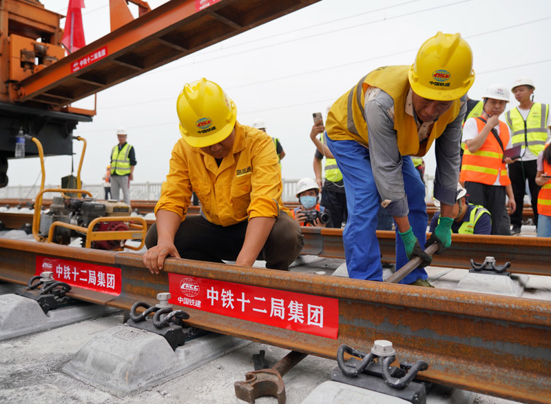 图为8月17日，中铁十二局工人在进行铺轨作业。（新华社记者 牟宇 摄）