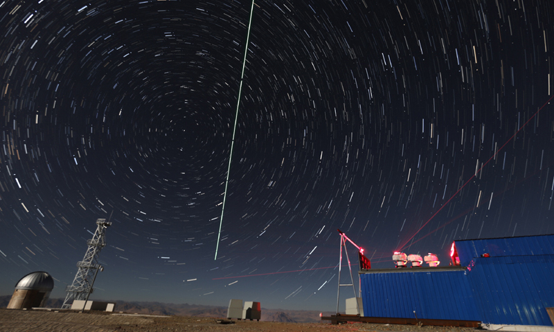 在西藏阿里观测站，“墨子号”量子科学实验卫星过境，科研人员在做实验（2016年12月10日摄，合成照片）。（新华社记者 金立旺 摄）